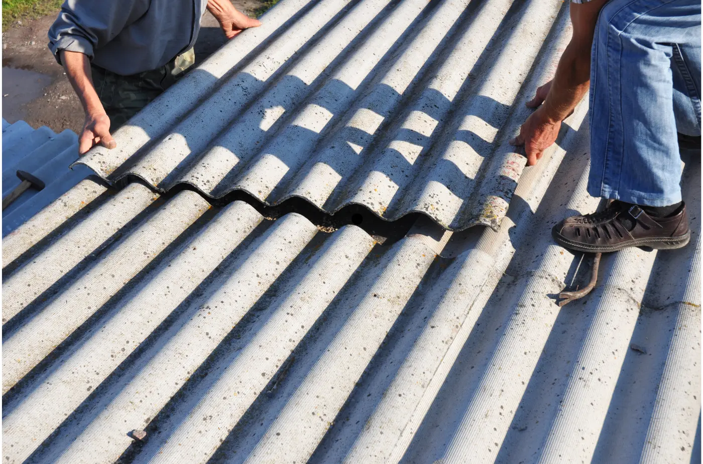 Two roofers fixing metal sheet on the roof