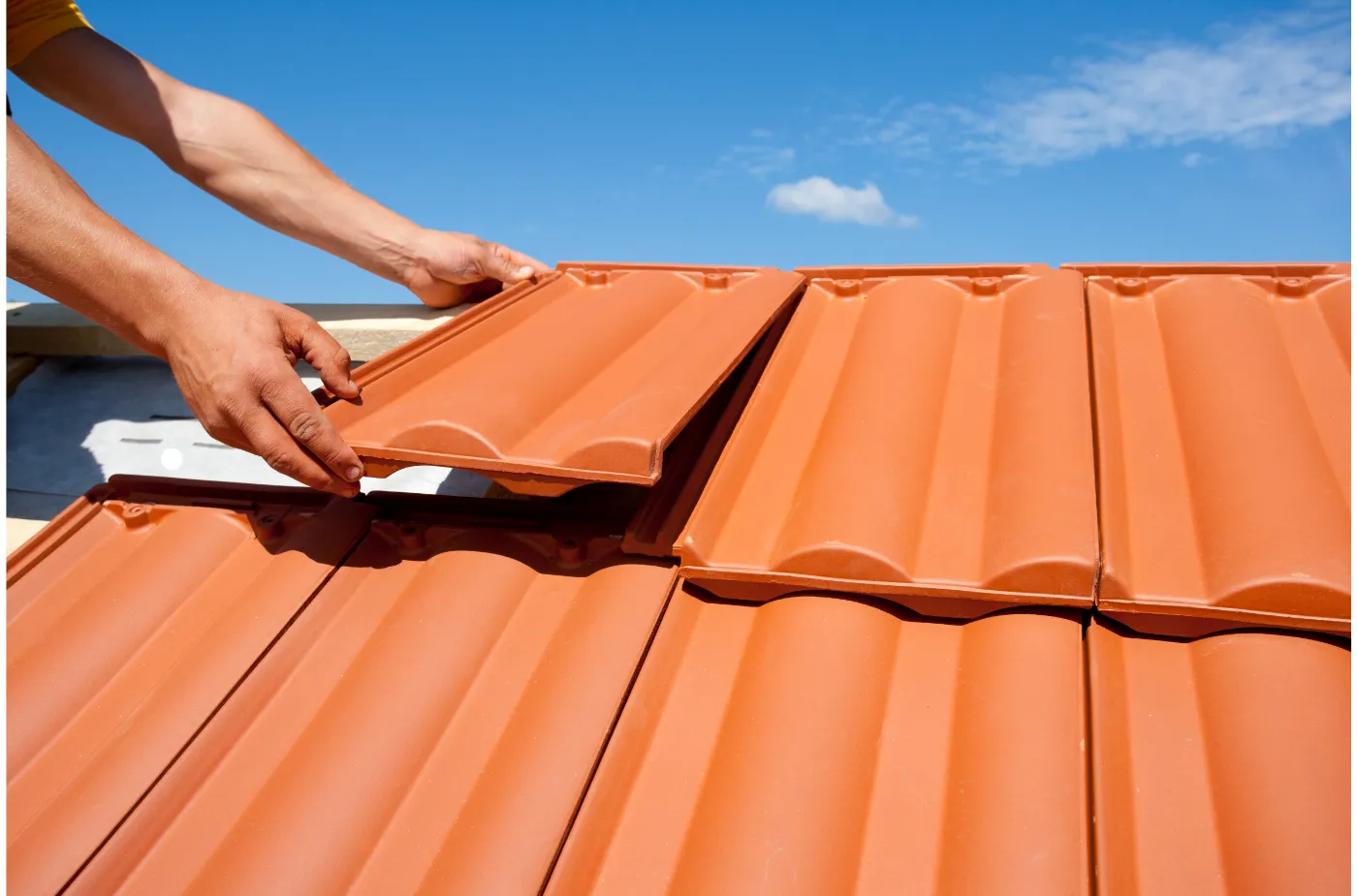 A man is fixing red tile on roof