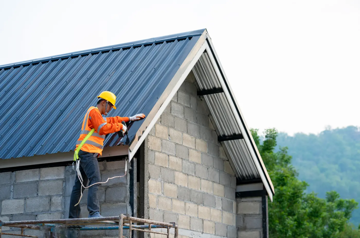 A roofer is fixing metal sheet on roof