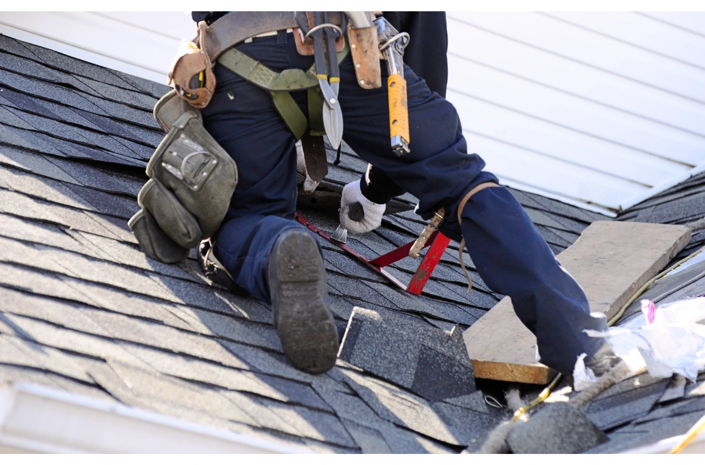 A roofer is fixing new shingles