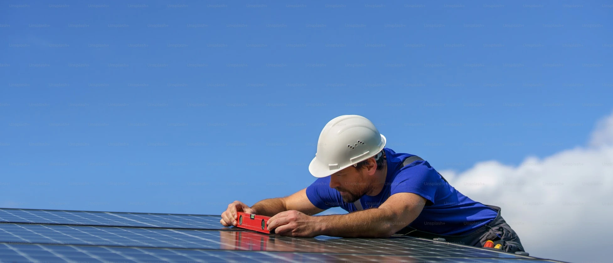 A worker wearing white helmet checking the roof level