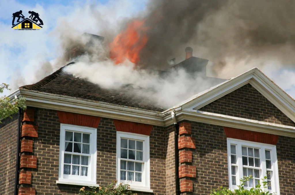 A house with smoke and visible flames coming from the roof during a fire.