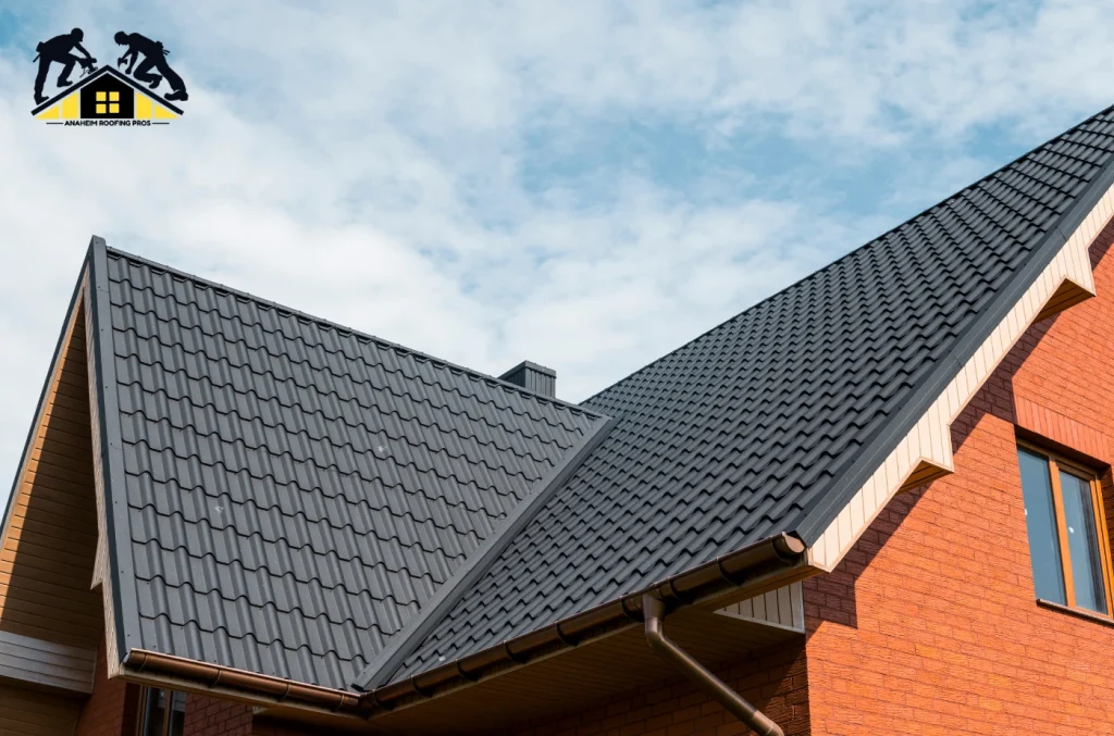 A house with a gray metal roof and brick exterior, shown from an angled view.