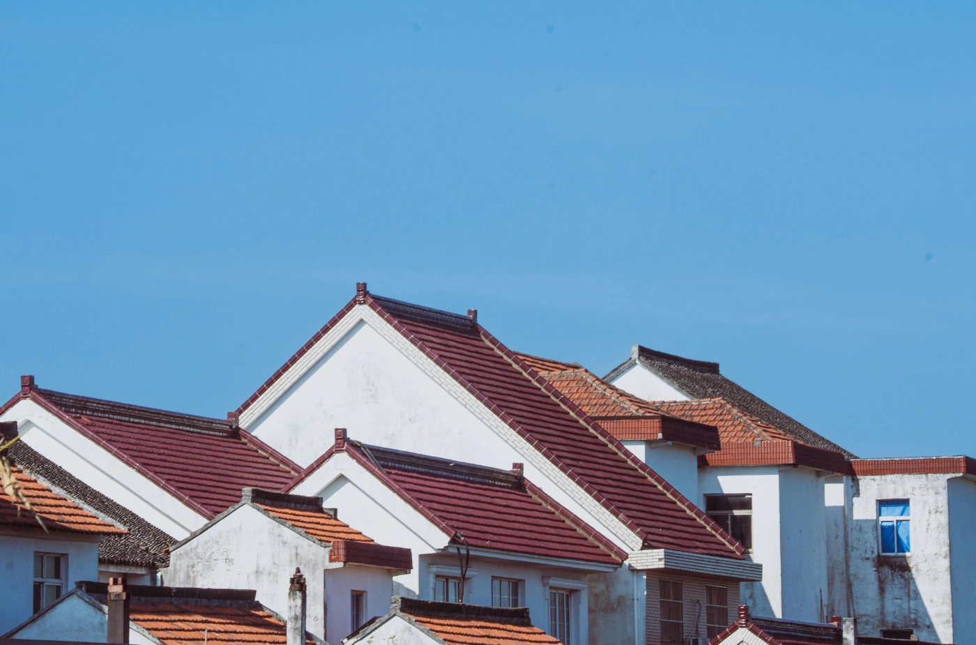 Residential homes with traditional sloped roofs and asphalt shingles.